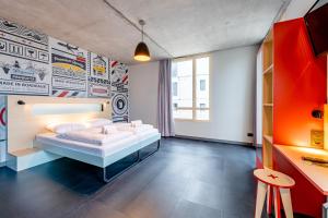 a bedroom with a bed and a wall with posters at MEININGER Hotel Bordeaux Gare Saint-Jean in Bordeaux