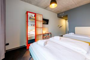 a room with two beds and a cabinet with two beds at MEININGER Hotel Bordeaux Gare Saint-Jean in Bordeaux