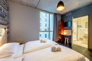 a bedroom with two beds with towels on them at MEININGER Hotel Bordeaux Gare Saint-Jean in Bordeaux
