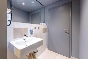 a bathroom with a sink and a shower at MEININGER Hotel Bordeaux Gare Saint-Jean in Bordeaux