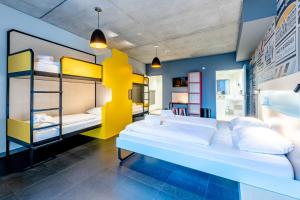 a room with two bunk beds and a tv at MEININGER Hotel Bordeaux Gare Saint-Jean in Bordeaux