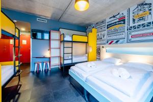a room with two beds and two bunk beds at MEININGER Hotel Bordeaux Gare Saint-Jean in Bordeaux
