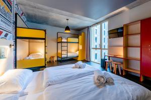 two beds in a room with two bunk beds at MEININGER Hotel Bordeaux Gare Saint-Jean in Bordeaux