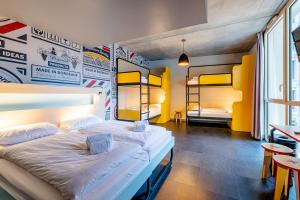 a bedroom with two beds and a table and chairs at MEININGER Hotel Bordeaux Gare Saint-Jean in Bordeaux