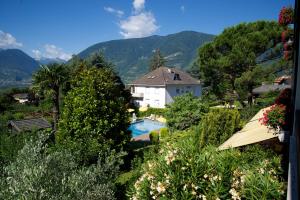 une maison dans les montagnes avec une piscine dans l'établissement Hotel Tannerhof, à Merano