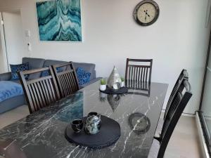 a dining room with a table and a clock on the wall at Melbourne Docklands Riverside Views in Melbourne