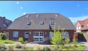 ein großes braunes Haus mit einem Gameradach in der Unterkunft FeWo-Norden in Norden