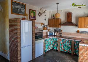 een keuken met een koelkast en een bakstenen muur bij El Quinto Pino in Canillas de Albaida