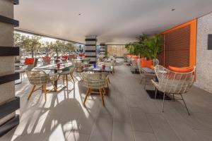 a restaurant with tables and chairs on a patio at Hotel Faro, a Lopesan Collection Hotel - Adults Only in Maspalomas