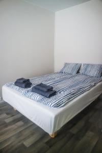 łóżko z dwoma czarnymi ręcznikami na górze w obiekcie Stay Kymi kalustetut huoneistot w mieście Kouvola