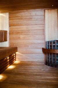 a room with a wooden wall with a bench and books at Stay Kymi kalustetut huoneistot in Kouvola