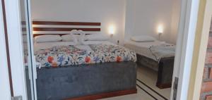 a bedroom with two beds and a mirror at Petit Guest House in Negombo