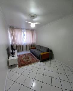 a living room with a couch and a table at Apto 2 Quartos, pertíssimo da Beira-Mar e Ponte HL in Florianópolis