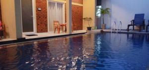 an empty swimming pool with a table and chairs at Petit Guest House in Negombo