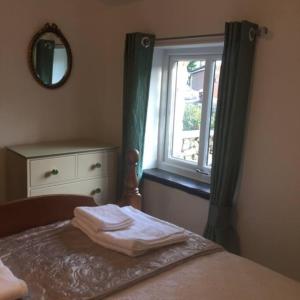 a bedroom with a bed with a window and a mirror at Dalesway cottage in Sedbergh