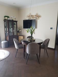 une salle à manger avec une table, des chaises et une télévision dans l'établissement Serce Nieznanego Boru, à Lipiny