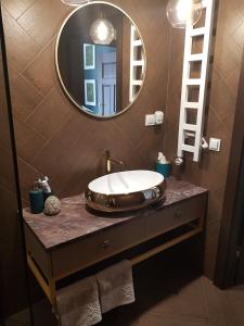 La salle de bains est pourvue d'un lavabo et d'un miroir sur un comptoir. dans l'établissement Serce Nieznanego Boru, à Lipiny