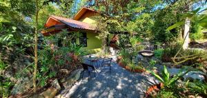 a garden with chairs and a house with trees at UTOPAI Stone Garden Vacation Home, Pai! in Ban Muang Soi