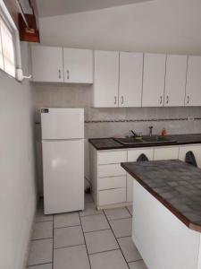 a kitchen with white cabinets and a white refrigerator at confort apto con balcones in Vega Alta