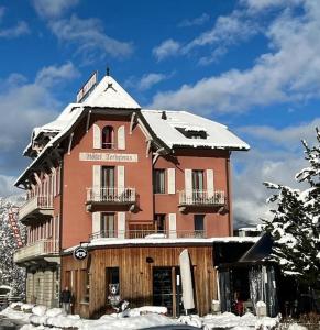un gran edificio con nieve encima en Hôtel Terminus, en Orsières