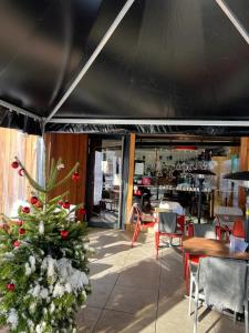 a restaurant with a christmas tree and tables and chairs at Hôtel Terminus in Orsières