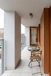 balkon ze szklanym stołem i krzesłem w obiekcie Awangarda Apartment Warsaw Ochota by Renters Prestige w Warszawie