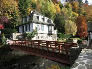a bridge over a river in front of a house at Historisches Haus im Herzen von Monschau in Monschau