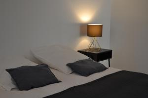 a bed with two pillows and a lamp on a table at Maison au cœur des Cévennes Méridionales in Saint-André-de-Majencoules