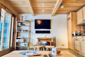 a kitchen with a table and a tv on the wall at The mountain charmer #AH11 in LʼHuez