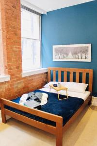 Bett in einem Zimmer mit blauer Wand in der Unterkunft Lovely Studio Apartment in the Heart of Nottingham in Nottingham