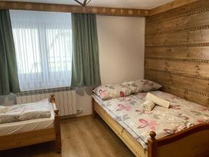 1 Schlafzimmer mit 2 Einzelbetten und einem Fenster in der Unterkunft Willa Dziubas z jacuzzi & sauną in Małe Ciche