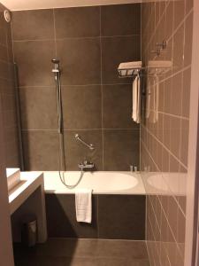 a bathroom with a white sink and a shower at Hotel Gemeente Huis in Nieuwpoort