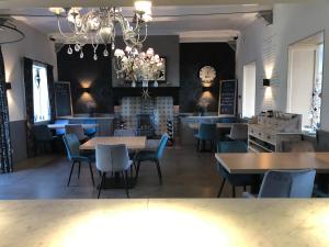 a restaurant with tables and chairs and a fireplace at Hotel Gemeente Huis in Nieuwpoort