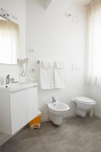 Baño blanco con aseo y lavamanos en Le Vette Room&Breakfast, en Rovereto