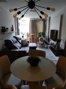 uma sala de estar com uma mesa e um sofá em Apartamento Vida Boa em Gravatal