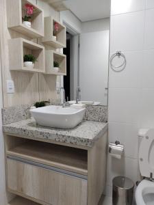 a bathroom with a sink and a toilet at Apartamento Vida Boa in Gravatal