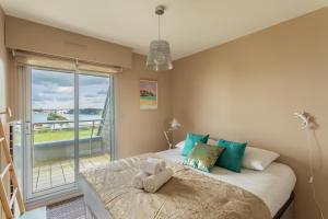 HEOL - appartement 2 chambres - vue mer et parking في دينارد: غرفة نوم مع سرير وإطلالة على المحيط