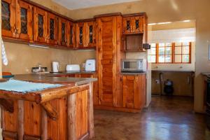 a kitchen with wooden cabinets and a counter top at Gecko Castle in Dullstroom