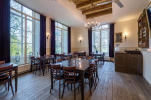 uma sala de jantar com mesas, cadeiras e janelas em Stayokay Hostel Utrecht - Bunnik em Bunnik
