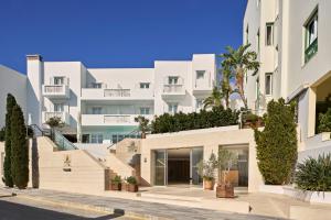 une image d'un bâtiment avec des plantes sur la façade dans l'établissement Oxygen Favie, à Tinos