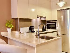 cocina con fregadero y nevera en Orzan Beach Surf Apartment en A Coruña