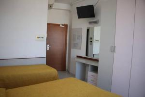a room with two beds and a sink and a mirror at Hotel Boston in Alba Adriatica