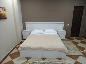 ヤンタルヌイにあるHotel Aquamarineのベッドルーム1室(白いベッド1台、ナイトスタンド2台付)
