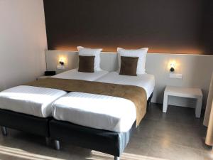 a bedroom with a large bed with two pillows at Hotel Gemeente Huis in Nieuwpoort
