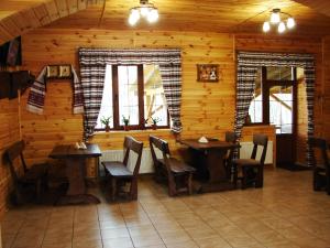 un restaurante con 2 mesas y sillas en una cabaña en Pershyi Kordon Tourist Complex, en Medvedevka