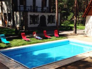 a group of chairs and a swimming pool at Pershyi Kordon Tourist Complex in Medvedevka