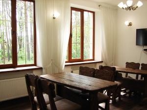 Un comedor con mesa y sillas y ventanas. en Pershyi Kordon Tourist Complex, en Medvedevka