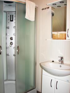 a bathroom with a glass shower and a sink at Pershyi Kordon Tourist Complex in Medvedevka