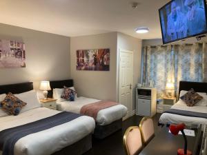 
a hotel room with two beds and a television at Leitrim Lodge in Carrick on Shannon
