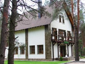 a white house with trees in front of it at Pershyi Kordon Tourist Complex in Medvedevka
